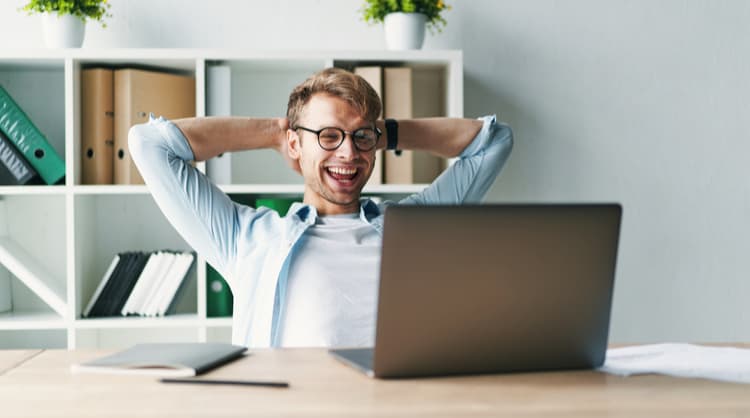 happy young man smiling at laptop