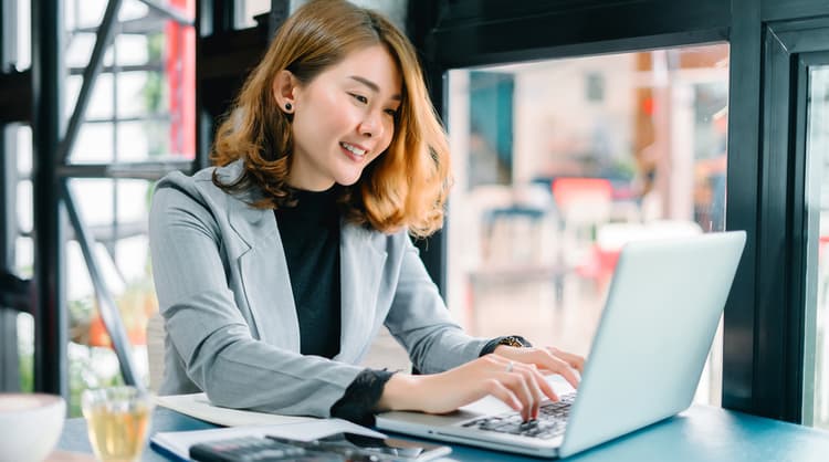 woman typing on laptop at a cafe