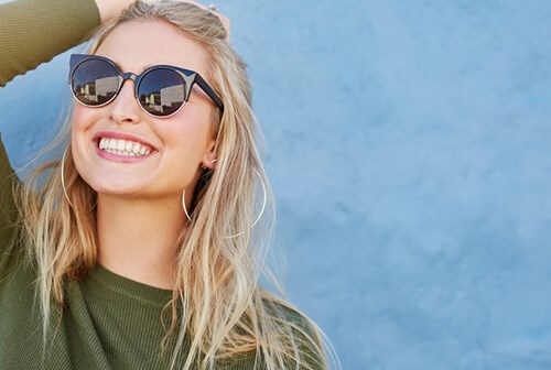 blonde hair woman smiling with sunglasses