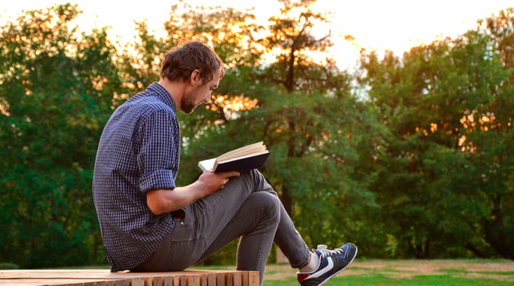 man reading a book outside