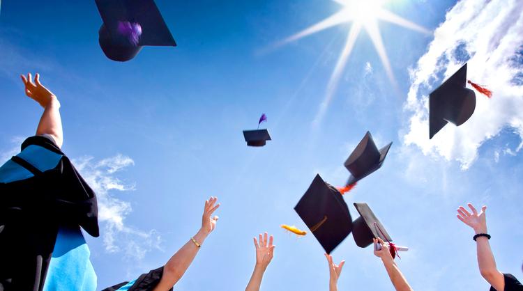 graduation caps in air