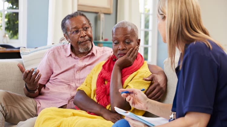 woman social worker talking to elderly couple