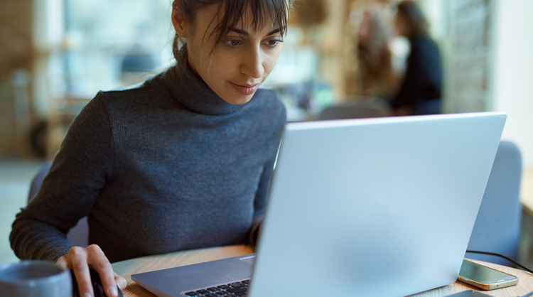 young woman working on laptop at cafe