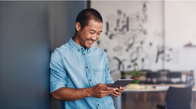 man smiling at digital tablet