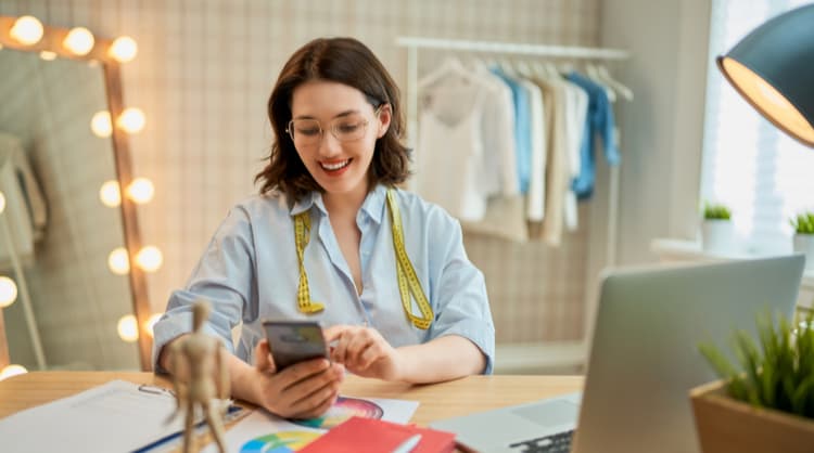 woman business owner smiling at smart phone