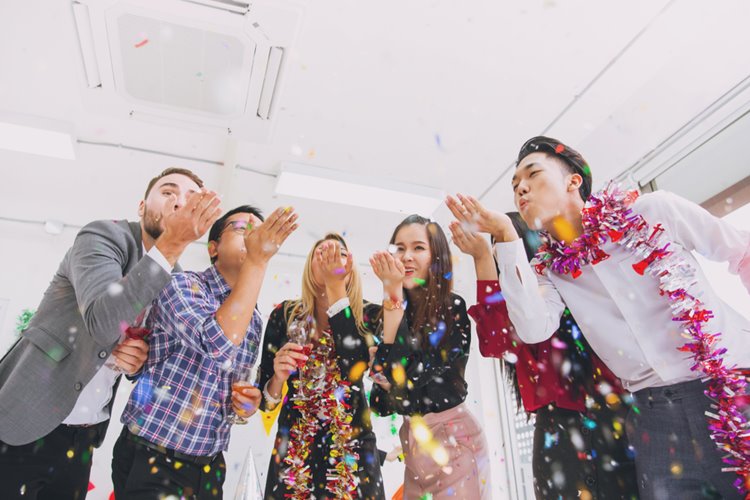 colleagues blowing confetti