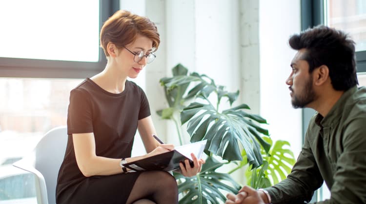 woman therapist taking down notes