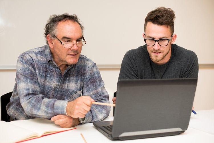 old man mentoring young male employee