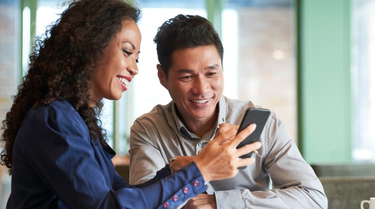 colleagues smiling at something on phone