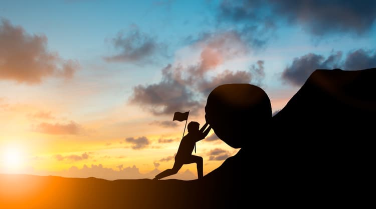 man pushing boulder