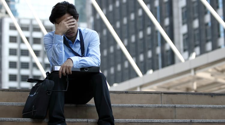 man sitting on steps looking stressed