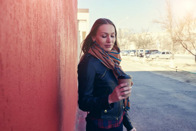 woman outside of work taking a walk with coffee in hand