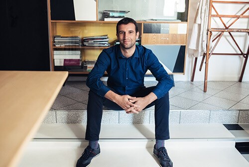 man with blue shirt sitting on step and smiling