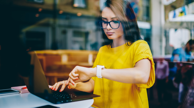 woman with glasses looking at watch