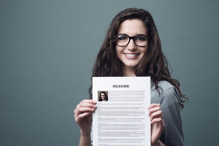 young woman with glasses holding resume