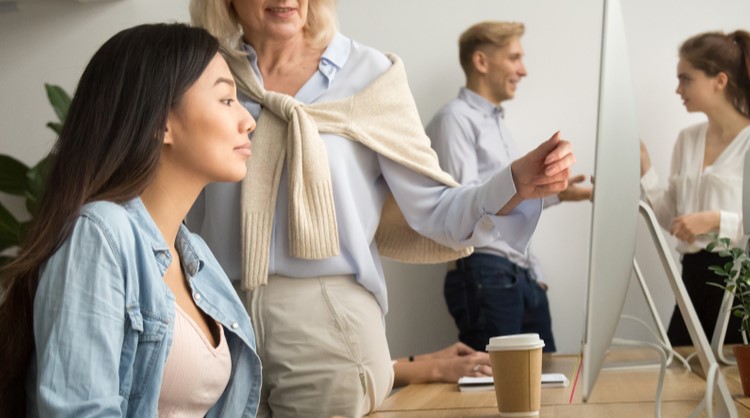 woman boss showing employee how to do things