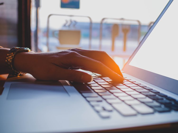 hands typing on laptop keyboard