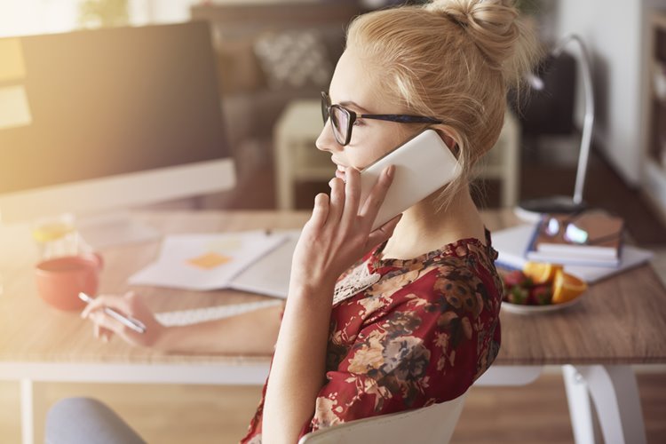 young woman talking on phone in home office