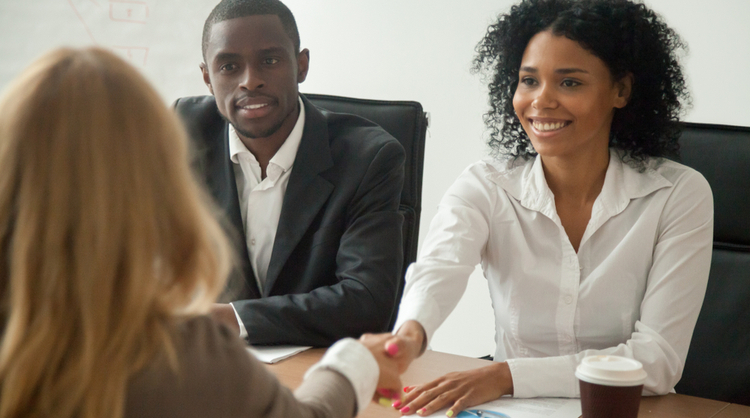 african american woman getting welcomed by HR team