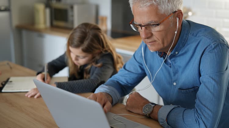 middle aged man working from home alongside daughter