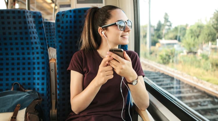 young woman smiling and listening to podcast