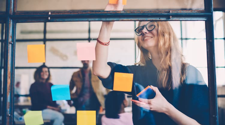 woman putting up post it note