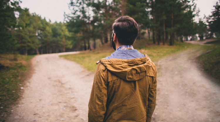 man walking deciding on which path to take