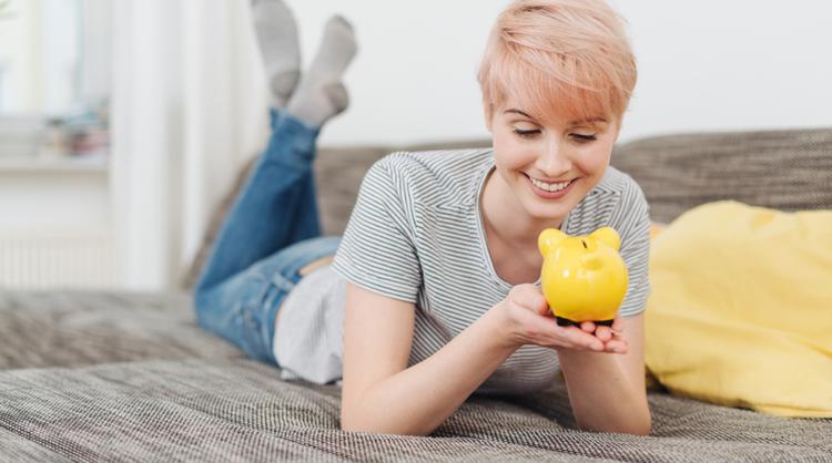 young woman smiling at piggy bank