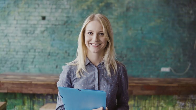 Blonde haired woman smiling with notebook