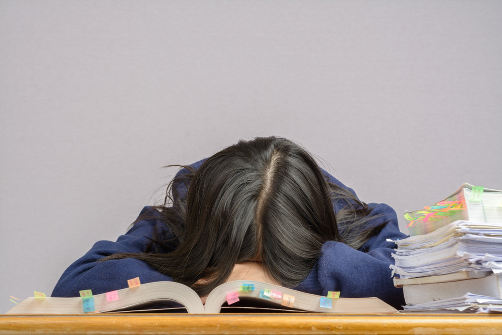 dark haired woman with head on desk