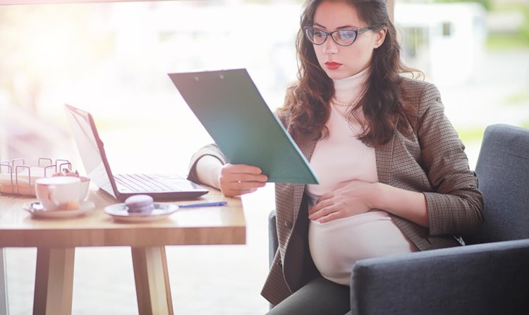 pregnant young woman with glasses working