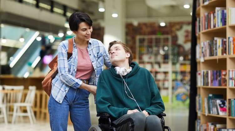 young support worker talking to man in wheelchair