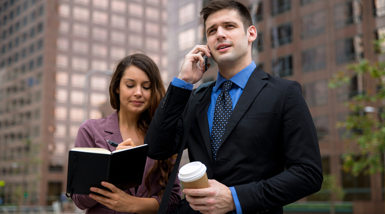 woman personal assistant taking notes alongside male manager