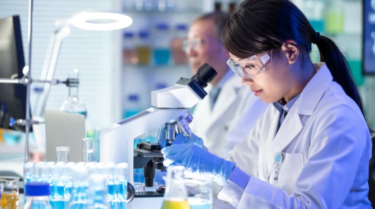 woman scientist looking through microscope