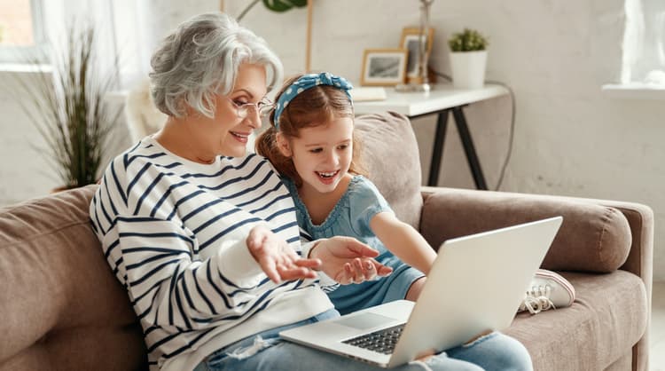 grandmother working on laptop with grandchild