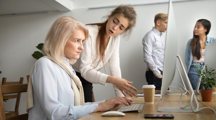 young team leader correcting older woman employee