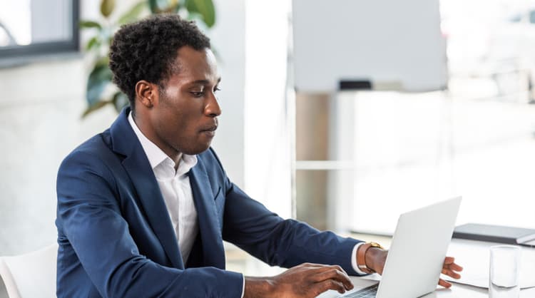 man typing on laptop