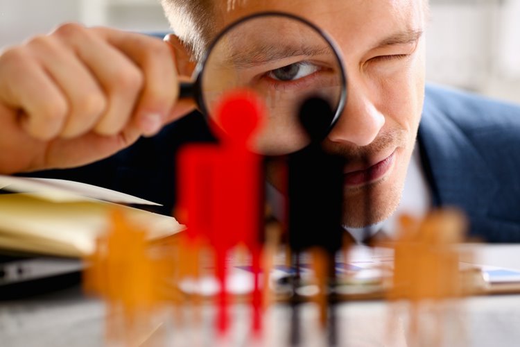 man looking through magnifying glass