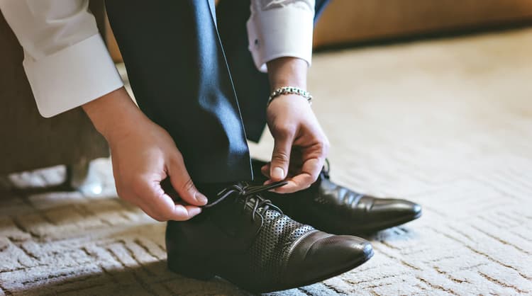 man tying shoe laces for work