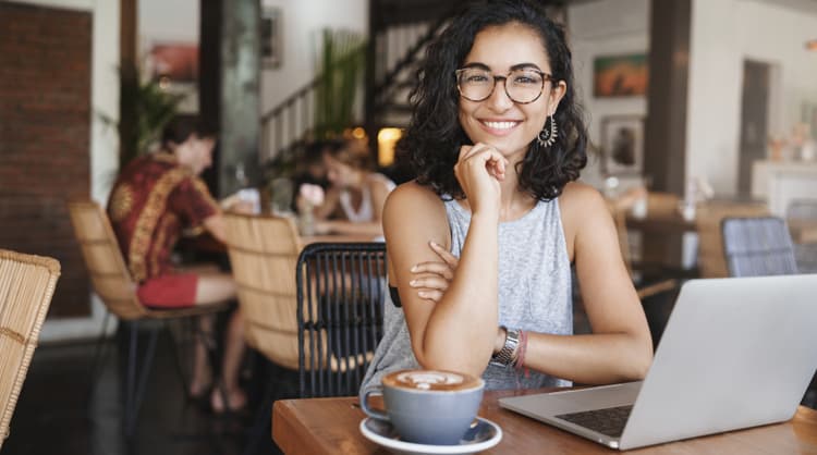 smiling young woman working from cafe