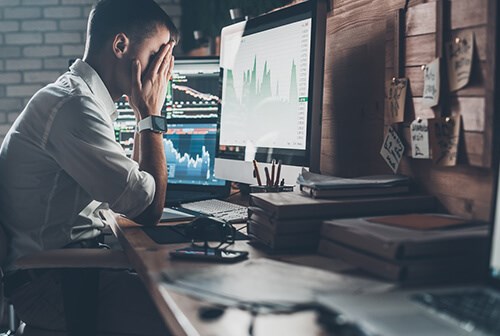 man with hands on his face facing graph