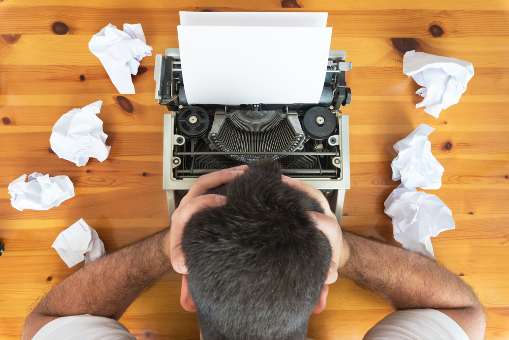 typewriter with scrunched up paper on desk