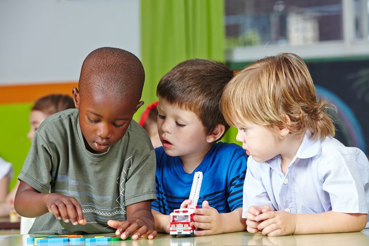 three little boys playing with toys