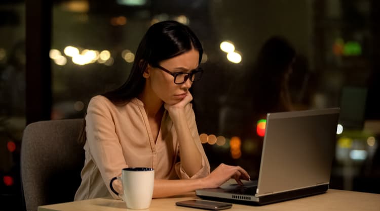 upset asian woman working on laptop