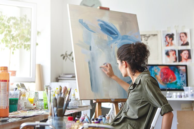 female artist painting on a canvas