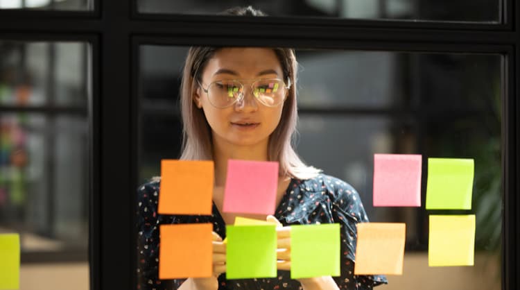 productive woman looking at post it notes