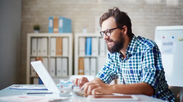 man typing on laptop