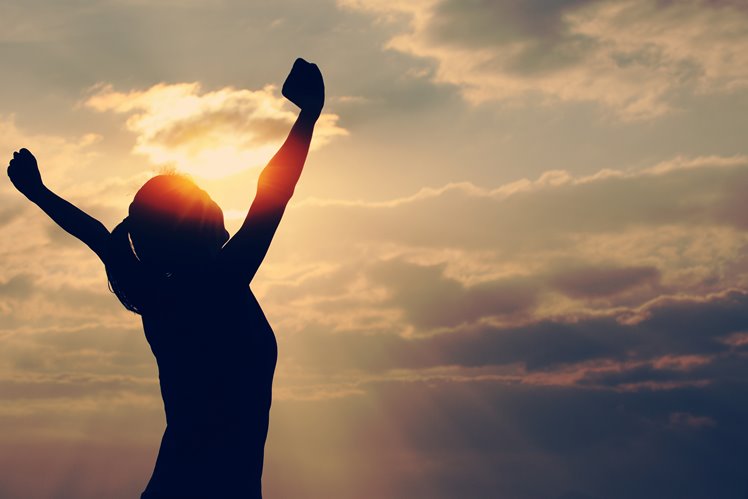 woman with arms in the air looking at nature