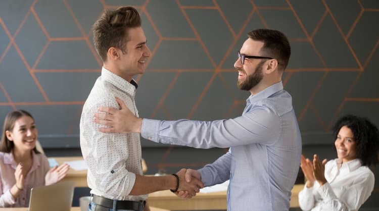 team leader shaking hands with employee