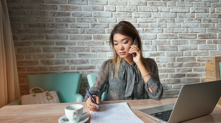 woman on phone taking notes